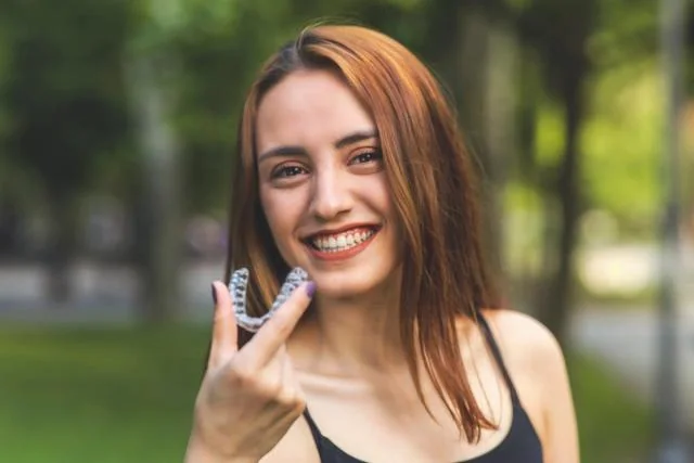Patient holding a clear orthodontic aligner