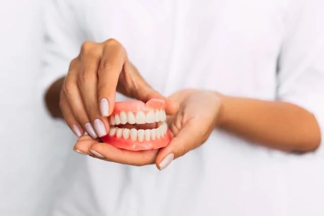 Patient holding a removable dental restoration