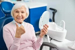 Denture patient checking her smile